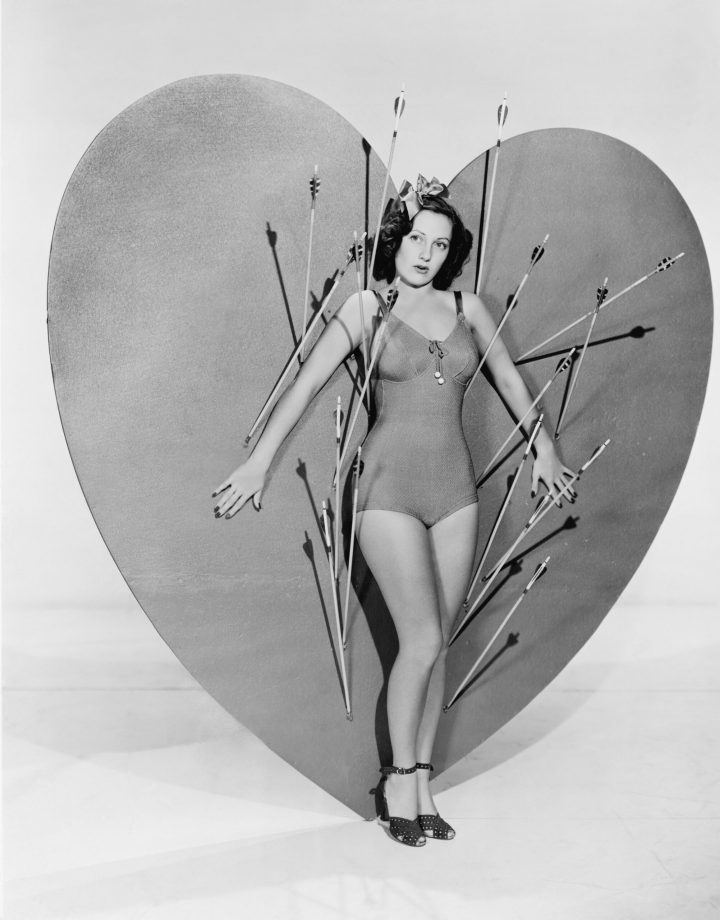 Woman surrounded by arrows on huge heart
